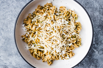 healthy plant-based food, vegan spinach and dairy-free cheese pasta bowl with wholemeal spirals