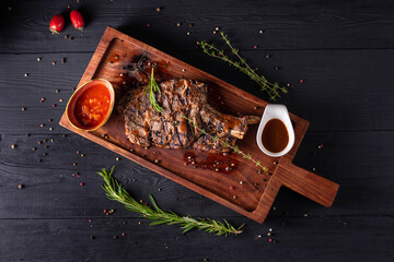 juicy beef steak with sauce. on a black wooden background