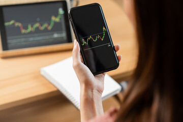Investor analyzing exchange market, asian young business woman, girl trader on graphic charts on tablet, smartphone for trading stock, looking at screen with diagrams at home office. Start up people.