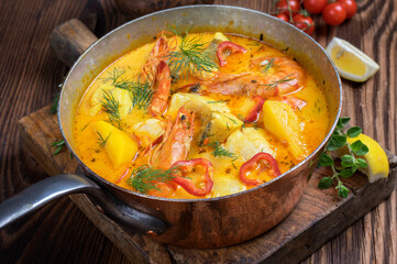 Traditional Brazilian fish soup moqueca de peixe with seafood and potatoes served as close-up in a...