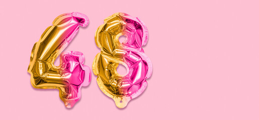 Rainbow foil balloon number, digit forty eight on a pink background. Birthday greeting card with inscription 48. Top view. Numerical digit. Celebration event, template. Banner