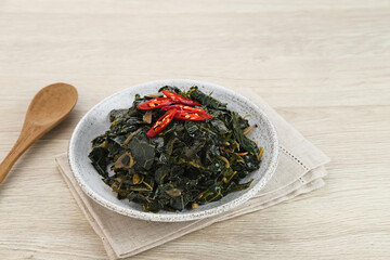 Stir Fry Papaya Leaves or Tumis Daun Pepaya, a traditional Indonesian dish made from boiled papaya leaves stir-fried with spices and chilies.
