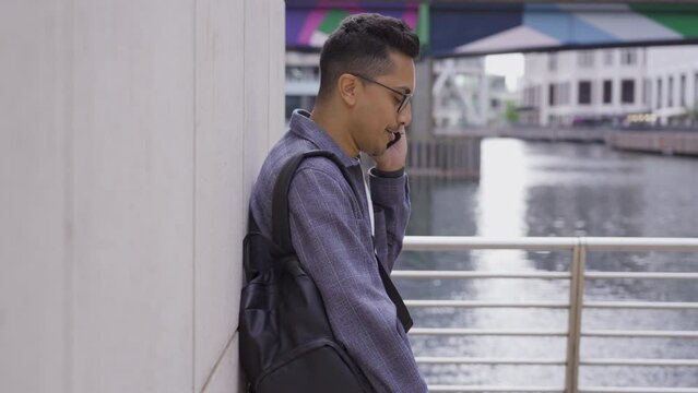 Tracking Shot of a Young Man Talking On Smartphone