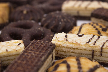 Chocolate biscuits and waffles on light background