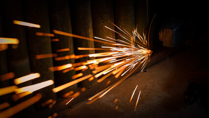 Flying sparks from an angle grinder being used at night