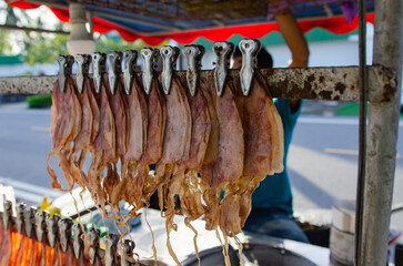 Fototapeta na wymiar Roasted and ground dried squid sold by the sea, soft focus.