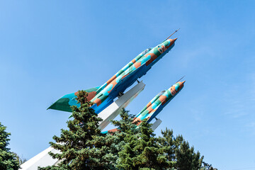 Two MiG-21MF planes on pedestal against blue autumn sky. Close-up. Two combat supersonic aircraft were installed on pedestal in early 80s of last century. Krasnodar, Russia - May 31, 2022 - obrazy, fototapety, plakaty