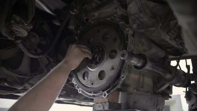 auto car mechanic installs flywheel