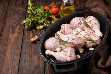 Raw chicken meat. Uncooked chicken legs on wooden cooking table background with spices. Copy space.
