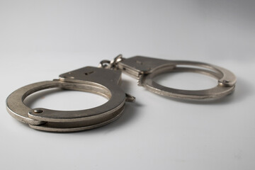 Metal handcuffs with a chain on a light background