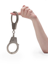Metal handcuffs with a chain on a light background in a female hand