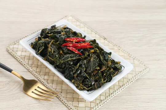 Stir Fry Papaya Leaves or Tumis Daun Pepaya, a traditional Indonesian dish made from boiled papaya leaves stir-fried with spices and chilies.
