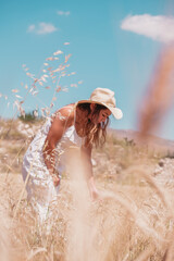 a woman in acamong the wheat ears at sunset