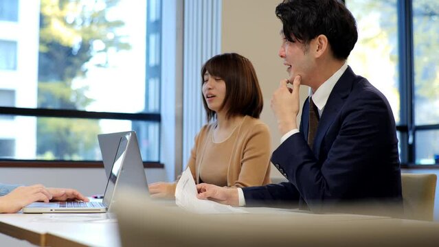 ノートパソコンで仕事をする日本人のビジネスイメージ