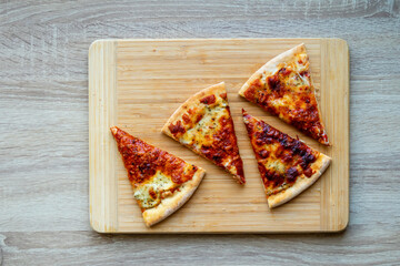 Slices of fresh pizza on a wooden table.