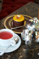 A cup of tea and a cake are on the table