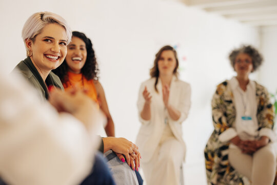 Businesswomen applauding their colleague during a meeting