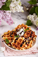 Belgian waffles with vanilla ice cream and chocolate topping. Breakfast for the family.