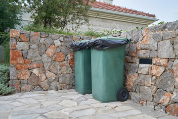 Obraz premium Green garbage cans next to the house on back yard