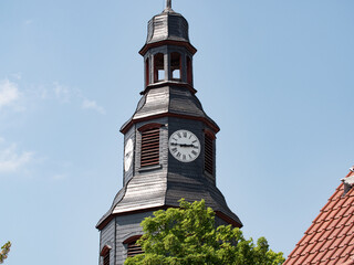 Close up church tower with clock. ancient clock with old clock-face. Sunny day with blue sky and...