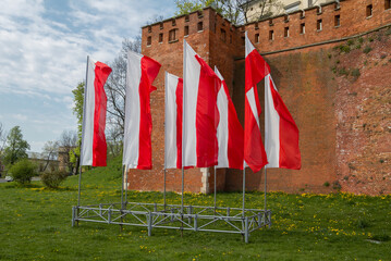 Polish national flags fluttering on a pole in Krakow. White and red banners of the Republic of...