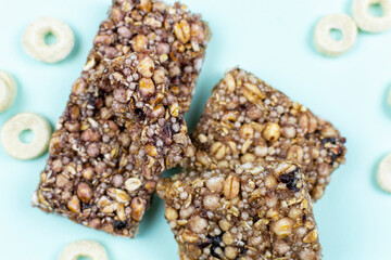 A bar with whole grains (muesli) for a snack on a blue background.