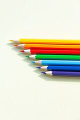 A large number of sharpened colored pencils with falling shadow from natural light on a bright sunny day.