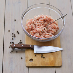 minced rice in glass on a wooden Board with a knife and spoon and scattered peppers