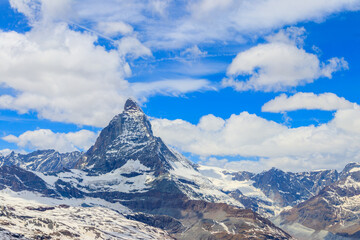 Scenic view on snowy Matterhorn mountain peak in sunny day with blue sky in Switzerland. Beautiful nature background of Swiss Alps covered with snow. Famous travel destination