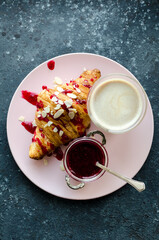 Croissant and jam with bouquet of pink tulips onblack background