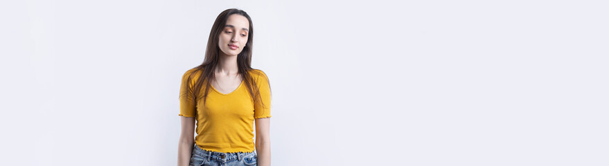 Fototapeta premium Portrait of a beautiful young woman thinking, isolated on concrete background