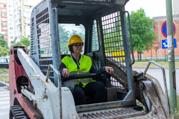 Cheerful female excavator operator on construction site. Woman construction apprentice learning to drive heavy equipment. female driving loader confidently, feminism and male work concept. 