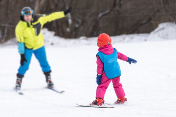 Instructor and little child skiing. toddler kid with safety helmet. Ski lesson for young children....