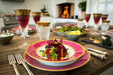 Beautiful wooden table set up for dinner fire in the fireplace closeup shot