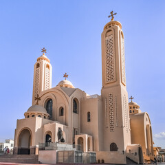 Sharm El Sheikh, Egypt - January 18, 2020: The modern building of the El sama Eyeen Coptic Church against the blue sky in Sharm El Sheikh. Exterior of an Egyptian Orthodox temple - obrazy, fototapety, plakaty