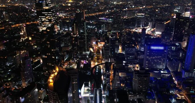 Bangkok city center hyperlapse timelapse aerial view. Big metropolis with skyscrapers at night, dark scenery cityscape. Office business buildings, asian agglomeration, cars moving on highways