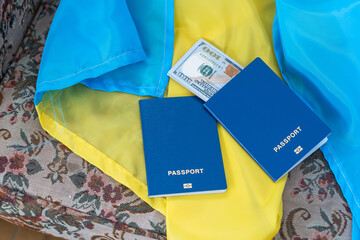 Biometric foreign passport with money lies on the national flag of Ukraine yellow-blue.