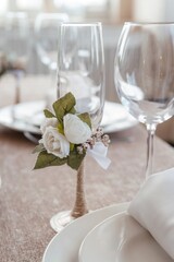 an empty champagne glass decorated with an artificial white fabric rose