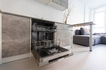 Modern kitchen with empty Built-in dishwasher with opened door, Stainless steel undermount kitchen...