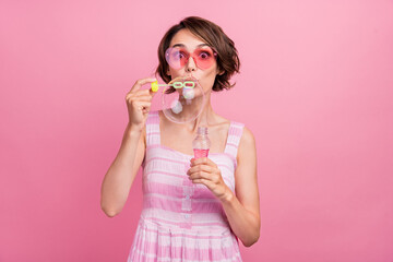 Photo of young girl amazed surprised blow big soap bubbles eyewear isolated over pink color background