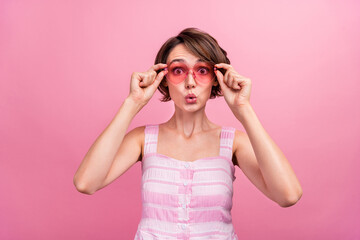 Photo of young girl amazed shocked put eyeglasses pouted lips reaction eyesight isolated over pink color background
