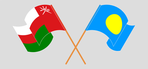 Crossed and waving flags of Oman and Palau