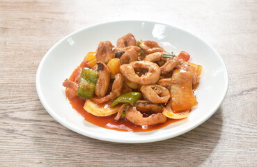 fried squid with slice bell pepper and onion with sweet and sour sauce on plate