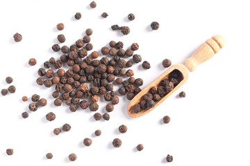 Heap of black pepper peas with wooden spoon isolated on white background. Herbs and spices.