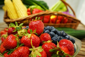 Fresh healthy strawberries and other fruits on a wooden table