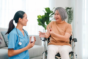 Female caregiver giving the medicine to her older female patient.