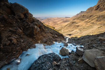 Mountain waterfall frozen at the Sani Pass, Drakensberg Mountains in South Africa.