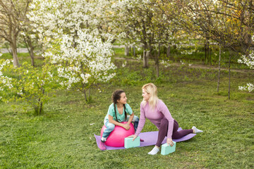 Fototapeta premium Mother and her daughter outdoors doing yoga, healthy lifestyle.
