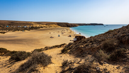 Golden sand washed by the clear turquoise waters of the Atlantic Ocean at Playa Mujeres, Playa Blanca, Yaiza, Lanzarote, Las Palmas, Islas Canarias, Spain, Europe.