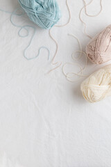 Fototapeta na wymiar Balls of cotton yarn pastel colors on a white table